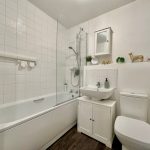 Modern white bathroom with bathtub and sink.