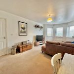 Cosy living room with brown sofa and TV.