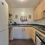 Modern kitchen with wooden cabinets and appliances.