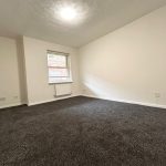 Empty room with grey carpet and window.