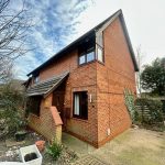 Two-storey red brick house with sloped roof.