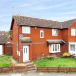 Red brick semi-detached house with garage, UK.