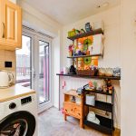 Small kitchen with appliances and shelves.