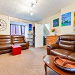 Cosy living room with brown leather sofas and decor.