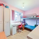 Pink bedroom with bunk bed and desk.