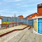 Wooden deck with houses and garden view