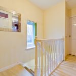 Bright hallway with mirror and white door.