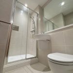 Modern bathroom with shower, sink, and toilet.