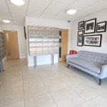 Modern lobby with mailboxes and seating area.