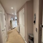 Modern hallway with white doors and decor.