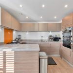 Modern kitchen with wood cabinets and built-in appliances.