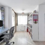 Bright room with desk, shelves, and colourful storage boxes.