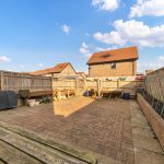 Spacious backyard with brick patio and garden area.