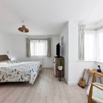 Bright bedroom with double bed and TV.