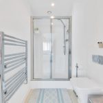 Modern bathroom with shower and towel rail.