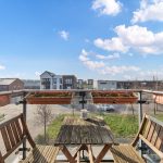 Balcony view over residential area with wooden furniture