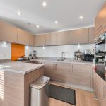 Modern kitchen with wooden cabinets and appliances.