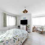 Bright bedroom with TV and floral bedspread.