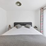 Modern bedroom with patterned decor and natural light.