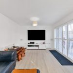 Modern living room with large TV and sofas.