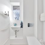 Minimalist white bathroom with sink and window