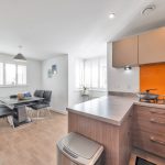 Modern kitchen and dining area with wooden flooring.