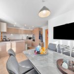 Modern kitchen and dining area with marble table.