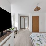 Modern bedroom with television and floral bedding.