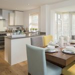 Modern kitchen with dining area and wooden floors.