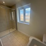 Modern bathroom with shower and frosted window.