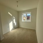 Empty room with window and carpet flooring.