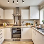 Modern kitchen with white cabinets and appliances.