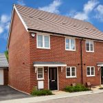 Brick semi-detached house with garages and driveway.