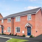 New red-brick semi-detached houses with blue doors.