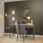 Modern home office with desk and large clock.