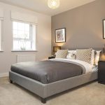 Modern bedroom with grey decor and natural light.