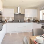 Modern kitchen with white cabinets and grey countertops.