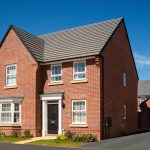 Modern red-brick house with black door and garage.