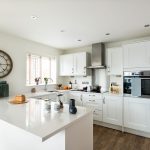 Modern kitchen with white cabinets and island counter.