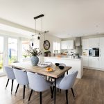 Modern kitchen with dining table and grey chairs.