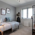 Modern bedroom with grey and white decor.