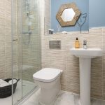 Modern bathroom with shower and pedestal sink.