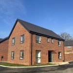 Modern red brick house with pitched roof.