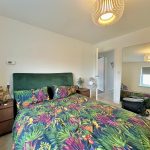 Colourful bedroom with a large wall mirror.