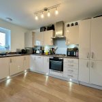 Modern kitchen with white cabinets and appliances.