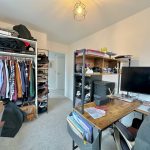 Home office with desk and wardrobe space.