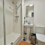 Modern bathroom with shower, sink, and toilet.