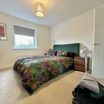 Modern bedroom with tropical-themed bedding and decor.