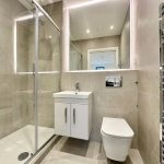 Modern bathroom with shower and vanity unit.