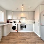 Modern white kitchen with appliances and wooden flooring